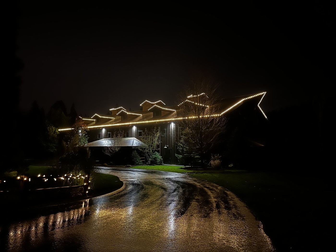 Home outlined in warm white lights in the fog